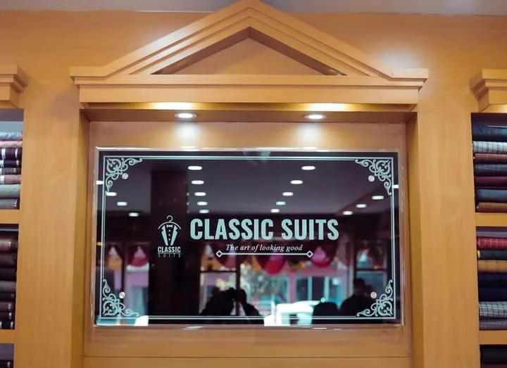 Inside Classic Suits on New Road, Pokhara — fabric-stacked walls flanking the Classic Suits sign.